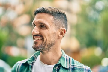 Young caucasian man smiling happy standing at the city.