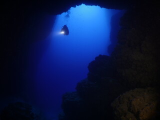 cave diving underwater scuba divers exploring caves ocean scenery sun beams and rays background