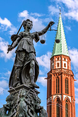 Gerechtigkeitsbrunnen auf dem Frankfurter Römerberg mit der Kirchturmspitze der Alten Nikolaikirche im Hintergrund