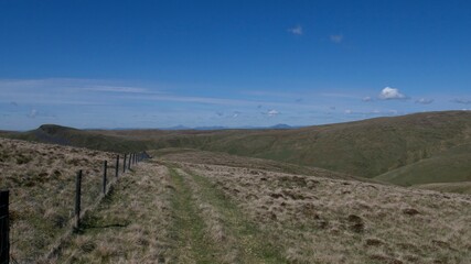 fence between pastures on top of Scottish hills on a hot summer day