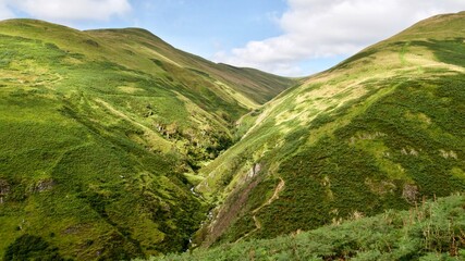 beautiful lush green valley between two hills in Scotland