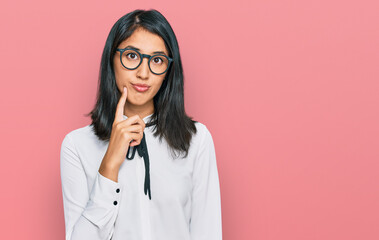 Beautiful asian young woman wearing business shirt and glasses serious face thinking about question...