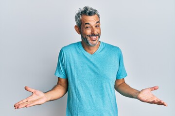 Middle age grey-haired man wearing casual clothes clueless and confused expression with arms and...