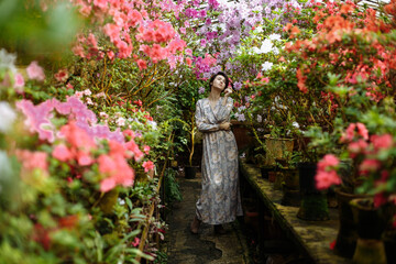 Obraz na płótnie Canvas a girl in a long dress in a big garden
