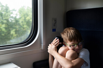 Fototapeta na wymiar Boy on the train. Travel by railway. Rules for traveling on train with children
