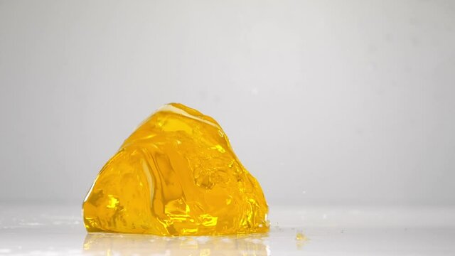 Falling jelly on white wet surface in slow motion.