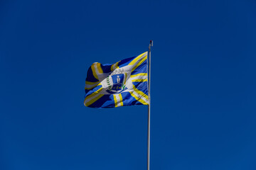 Bandeira da cidade de Anápolis balançando ao vento com o céu azul ao fundo. Foto feita na cidade de Anápolis em Goiás, Brasil.
