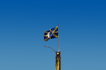 Bandeira da cidade de Anápolis balançando ao vento com o céu azul ao fundo. Foto feita na cidade de Anápolis em Goiás, Brasil.