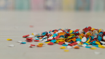 Party time concept. Colorful confetti decoration on a wooden table. Selective focus.