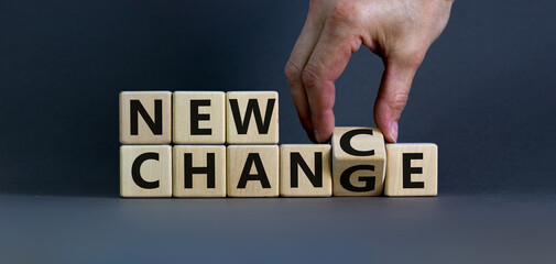 New change - new chance. Hand flips a cube and changes the words 'new change' to 'new chance'. Beautiful grey background, copy space. Business and new chance concept. - obrazy, fototapety, plakaty