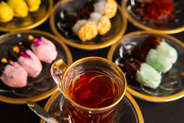 Tea with saffron, dates with chocolate on black background