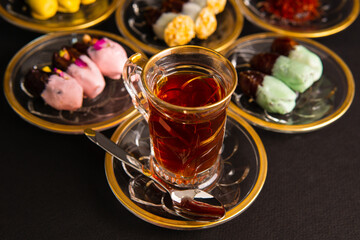 Tea with saffron, dates with chocolate on black background
