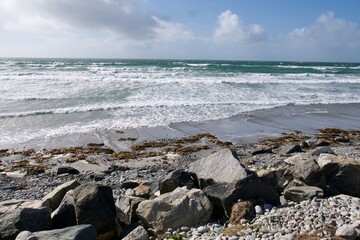 Fototapeta na wymiar Rocky beach next to a wild ocean on a sunny summer day in the Outer Hebrides