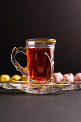 Tea with saffron, dates with chocolate on black background