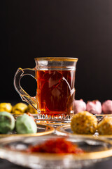 Tea with saffron, dates with chocolate on black background
