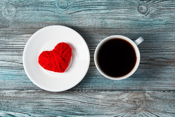 Romantic background with red heart, saucer and coffee Cup on grey-blue wooden background. Top view with space to copy. Concept of holiday backgrounds.