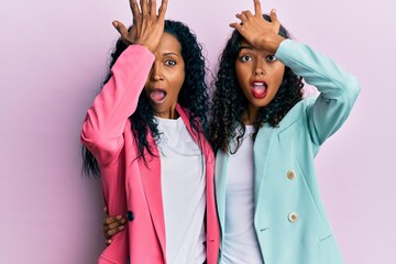 African american mother and daughter wearing business style surprised with hand on head for...