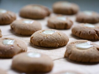 Fototapeta na wymiar many small round freshly baked ginger, honey and cinnamon cookies with a creamy eye assorted on a chopping board