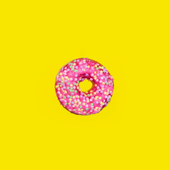 Pink glazed donut  on bright yellow background