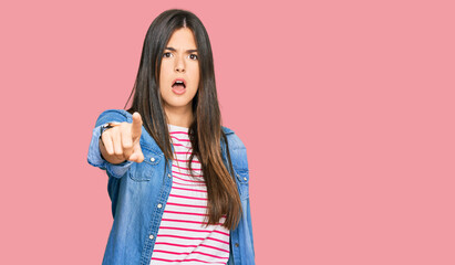 Young brunette woman wearing casual clothes pointing displeased and frustrated to the camera, angry and furious with you