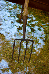 Iron village pitchfork on the frozen ground in the village