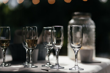 Champagne glasses at the blurred background with the place for your text. Wine glasses. Alcohol party. Empty and full glasses