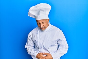 Middle age grey-haired man wearing professional cook uniform and hat with hand on stomach because indigestion, painful illness feeling unwell. ache concept.