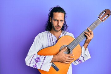 Obraz premium Young handsome man with long hair playing classical guitar skeptic and nervous, frowning upset because of problem. negative person.