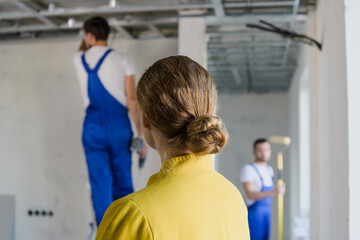 Obraz premium A woman looks at the work of a builder. She stands with her back to the camera