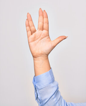Hand of caucasian young woman doing freaky star trek salutation over isolated white background