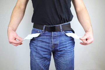 The concept of the financial crisis. The Caucasian man turned the empty pockets of his trousers...