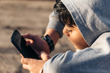 Portrait of little Indian boy using mobile phone indoor. Concept of mobile phone, technology addiction in young children