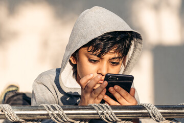 Portrait of Indian kid using mobile phone while sleeping