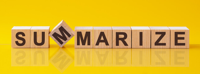 summarize word is made of wooden building blocks lying on the yellow table, concept