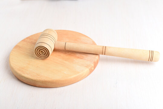 Wooden hammer for beating meat on a wooden kitchen Board.