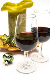 Popular british christmas drink, glass of vintage ruby port wine and candle with christmas tree decoration