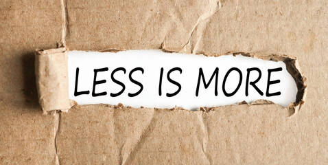 less is more, text on white paper on torn paper background