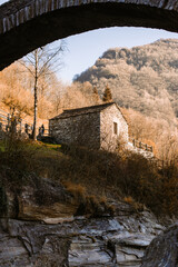 old bridge in the mountains with a stone house