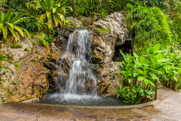 Fototapeta na wymiar A long exposure view of a waterfall in the Botanical Gardens in Singapore, Asia