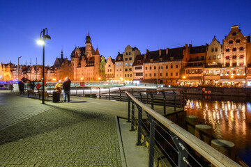 Promenade at Motlawa River with famous historic architecture of Gdansk at night. Poland, Europe.