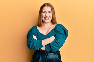 Young beautiful redhead woman wearing elegant and sexy look happy face smiling with crossed arms looking at the camera. positive person.