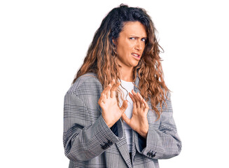 Young hispanic woman with tattoo wearing business oversize jacket disgusted expression, displeased...