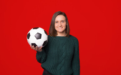 Photo young woman holding soccer ball over isolated background with toothy smiling wearing gray sweater