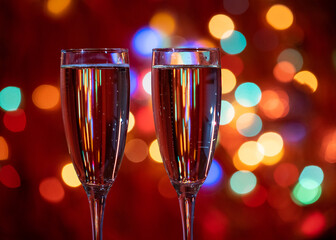 Champagne glass close up on Christmas and New Year holiday bokeh background. Two glasses with bubbly tasty sparkling drink. Happy New Year! Celebrating winter holidays, 4K, close up, macro