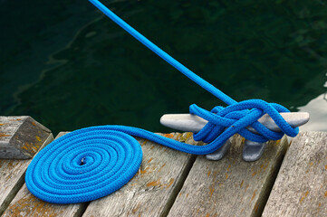 Coiled blue rope tying a boat to the dock