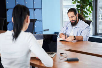 Concentrated man is sitting at desk
