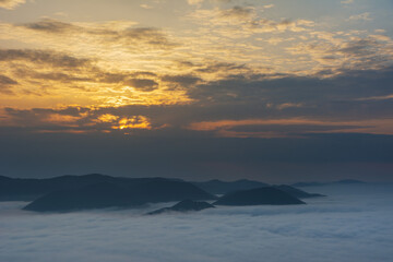 Beautiful sunrise in the Carpathian mountains with fog and dramatic sky