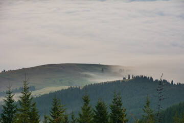 Beautiful sunrise in the Carpathian mountains with fog and dramatic sky