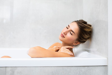 Young beautiful woman relaxing in bathtub at home