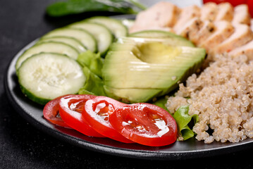 Fresh delicious salad with quinoa, chicken and fresh vegetables on a plate